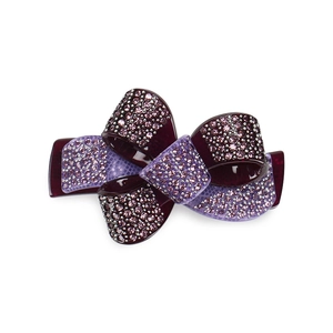 Close-up of elegant acrylic bow hair clip with purple rhinestones and ribbon buckle