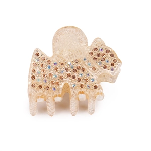 Détail d'une pince à cheveux petit chien blanc avec strass et texture quadrillée