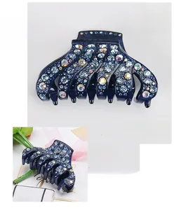Close-up of a blue acrylic hair claw clip with rhinestones and 9x5cm dimensions