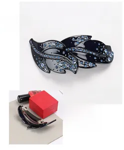 Detail view of leaf shape hair clip with blue rhinestones and spring mechanism