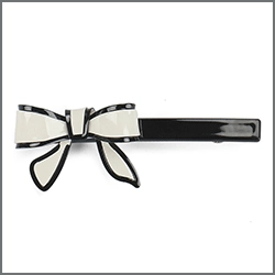 Detail of a chic black and white resin hair clip with a sleek bow design and glossy finish
