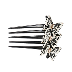 Detail of elegant black and white bow hair comb featuring sparkling crystals and five teeth