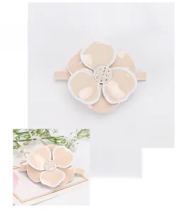 Detail view of large acrylic camellia flower hair clip with sparkling rhinestones and white edges