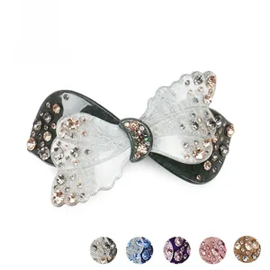 Détail macro d'une pince à cheveux papillon en acétate avec strass brillants et multi-couleurs