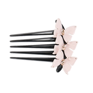 Close-up of pink 3D butterflies and marquise crystals on a black 5-tooth hair comb