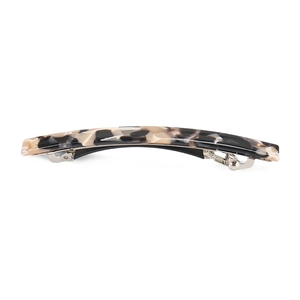 Macro view of leopard print acetate hair clip showing the curved shape and metal spring
