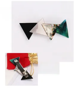 Detail view of acetate geometric hair clip with four color triangles and metal duckbill clip
