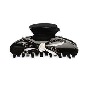 Pince à cheveux noeud en acrylique noir avec strass colorés et détails dorés brillants