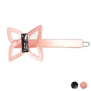 Pince à cheveux papillon en acétate rose avec cristal gris sur un fond blanc neutre