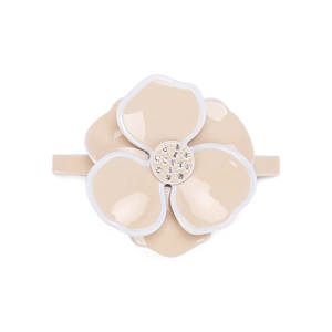Macro view of a large cream camellia hair clip with white petal edges and shiny rhinestones