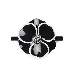Close-up of black and white camellia hair clip with sparkling crystal center