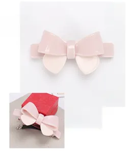 Pink acrylic bow hair clip detailed view showing 8.5x4.2cm dimensions and glossy finish
