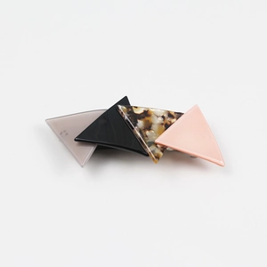 Detail of geometric acetate hair clip with gray, black, tortoiseshell and pink triangles