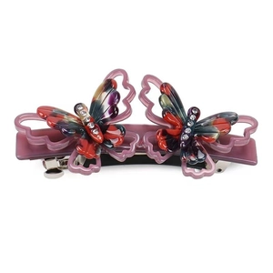 Détail de la pince à cheveux papillon en acétate violet avec strass et ressort métallique