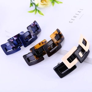 Close-up of geometric acetate hair clips with marble patterns and metal spring clips