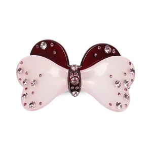 Dettaglio del fermaglio a fiocco in acrilico con strass rosa in rosso e rosa chiaro