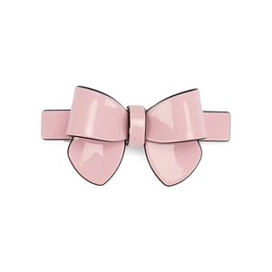 Close-up of a light pink acetate bow hair clip with black edge detailing and high gloss