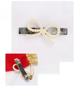 Close-up of French acetate bow hair clip with faux pearls and metal spring clip details