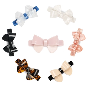 Set of seven colorful acetate bow hair clips in various elegant marble and solid patterns