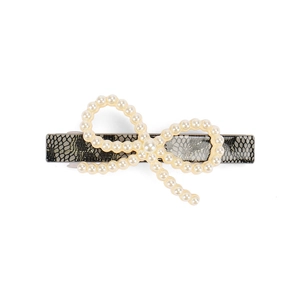 Detail view of acetate hair clip with black lace pattern and white faux pearl bow ornament