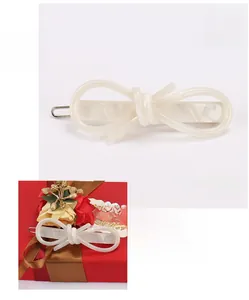 Detailed view showing a 6.5x2cm acetate bow hair clip with white marble texture