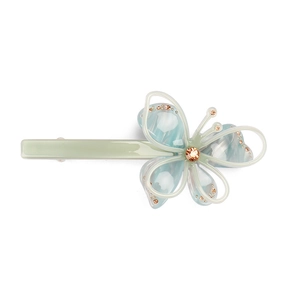 Close-up of acetic acid butterfly hair clip with sparkling orange diamonds and blue wings