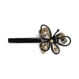 Macro shot of marble texture acetate butterfly hair clip with gold rhinestones details