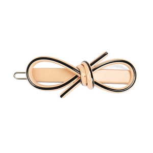 Detail view of the pale orange bow hair clip with black stripes and silver metal clasp