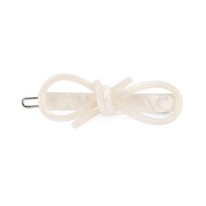 Detail of a creamy marble acetate bow hair clip with silver metal spring fastener