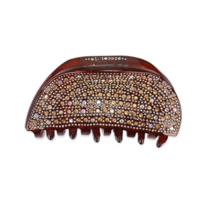 Détail de la pince à cheveux en acrylique avec strass ambre et reflets irisés de luxe