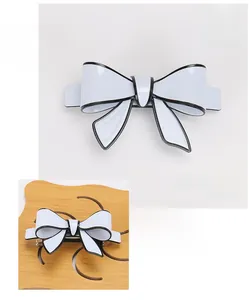Detailed specs of the white acrylic bow hair clip showing dimensions 8.7x4.8cm and 22g weight