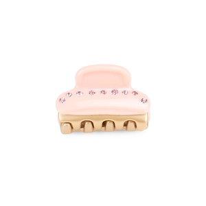 Dettaglio della piccola molletta per capelli in acetato rosa con strass e denti dorati