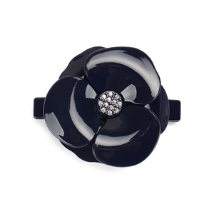 Detailed view of navy blue camellia hair clip with glossy resin and sparkling crystals