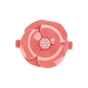Detail of coral pink camellia hair clip with glossy resin petals and crystal center