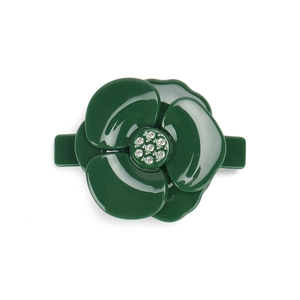 Detailed view of dark green camellia hair clip with glossy finish and crystal center