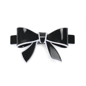 Detailed view of the sleek black acrylic hair clip with white trim and spring fastener