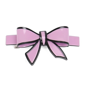 Detailed close-up of pink acrylic bow hair clip with black edges and metal spring fastener