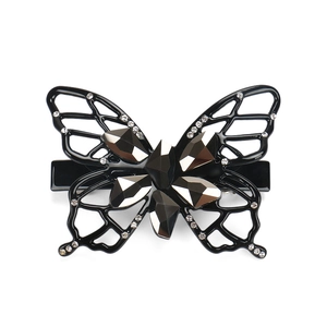 Detailed close-up of hollow butterfly hair clip with large crystals and small rhinestones