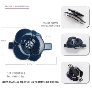 Détail de la barrette camélia en acétate bleu foncé avec strass et pince en métal