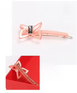 Detail of pink acetate butterfly hair clip with gray rectangular crystal and metal spring