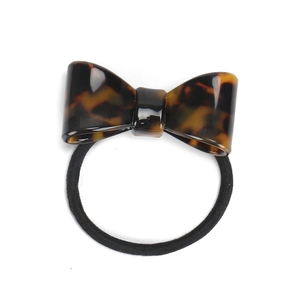 Detailed view of leopard print bow hair tie made of glossy acetate with black elastic band
