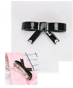 Dettaglio del fermaglio per capelli a fiocco in acetato nero con strass e clip a molla