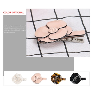 Elegant camellia hair clips set with rhinestones in multiple colors on grid background