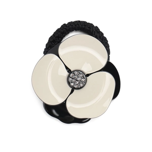 Detail of camellia hair tie with black and white resin petals and rhinestone center
