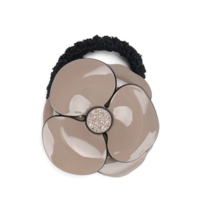 Close-up of acetic acid camellia flower hair tie with sparkling crystals on elastic band
