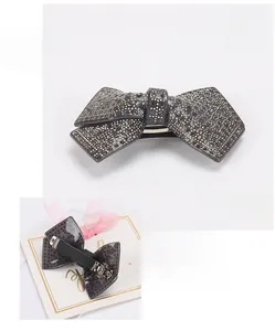 Detail view of large bow hair clip with black rhinestones and spring clip mechanism