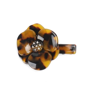 Detailed macro view of tortoiseshell acetate flower hair clip with sparkling rhinestones