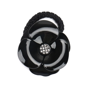 Detailed view of the black camellia flower hair tie with sparkling crystal center