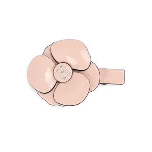 Detailed close-up of a pink camellia hair clip with crystal center on a white background