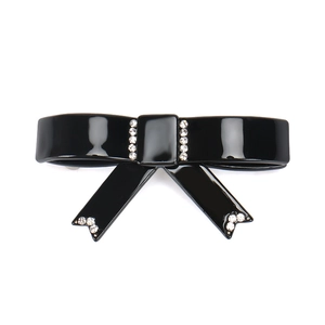 Dettaglio della clip per capelli a fiocco in acetato nero con strass e molla in metallo